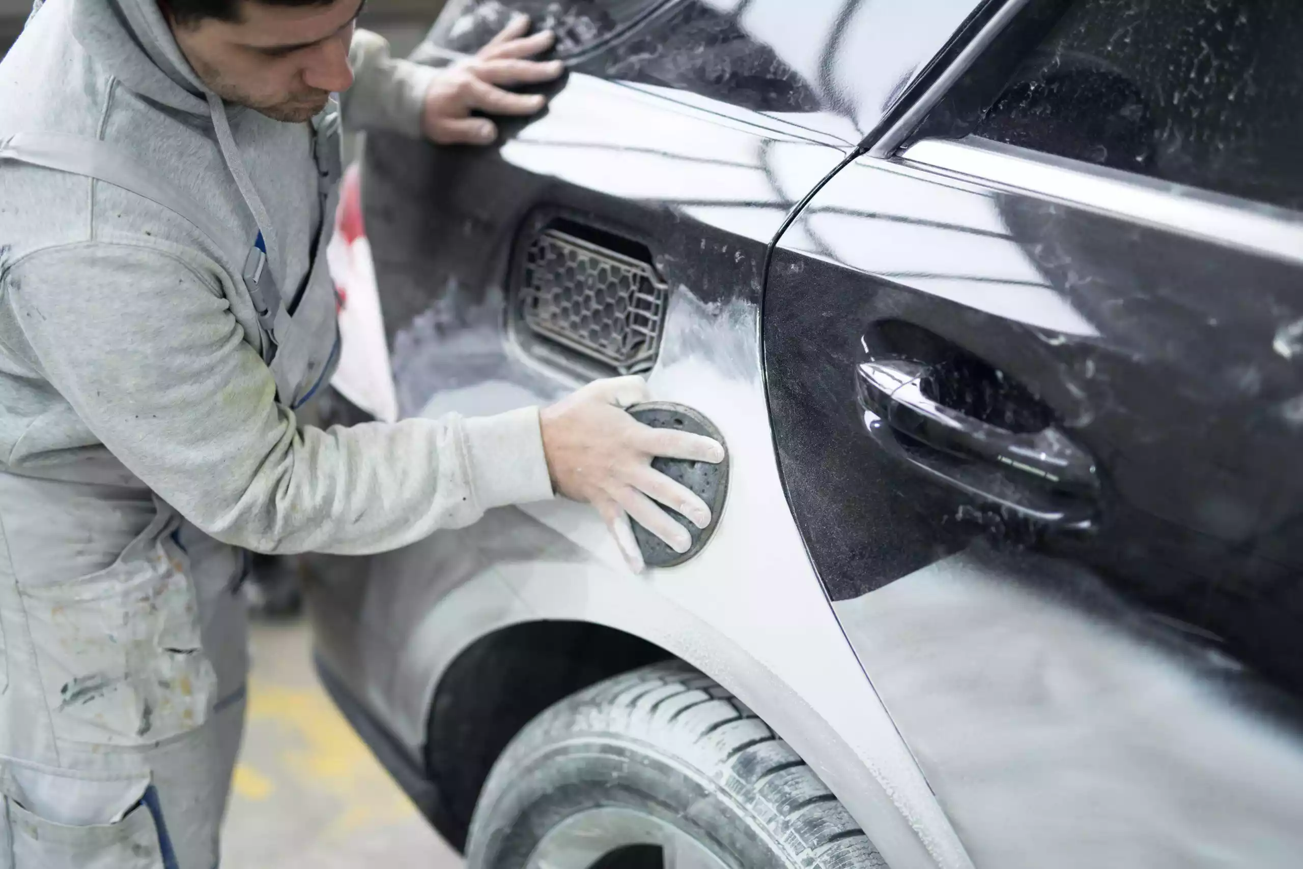A technician preparing a car for painting at Network Auto Body’s advanced workshop.